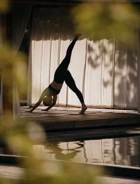 Woman holding a yoga pose in a sunlit studio