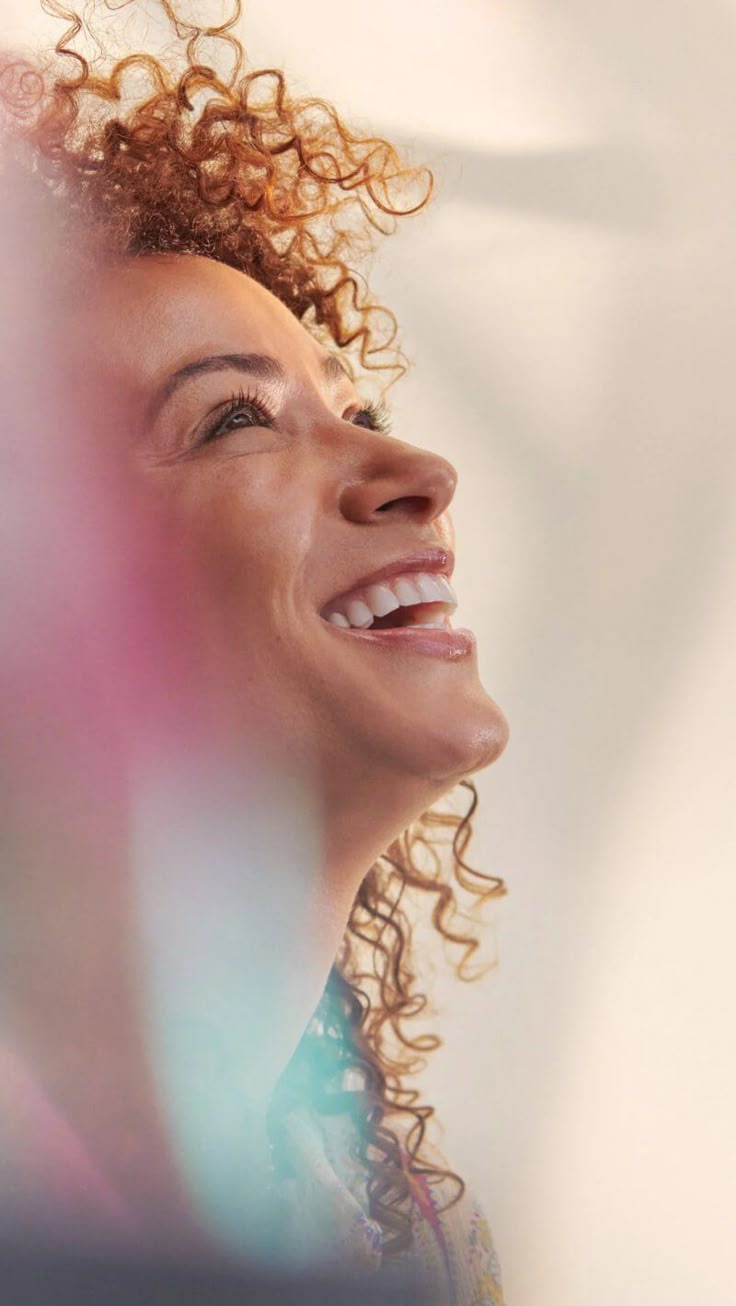 Woman smiling and looking upward in warm light